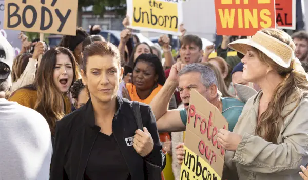 Kate Walsh nei panni di Addison Montgomery che cammina tra i manifestanti anti-aborto in Gray
