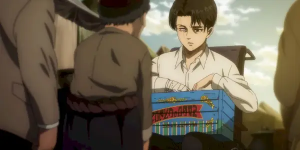 Levi sitzt im Rollstuhl und blickt in „Attack on Titan“ mit einem verlorenen Auge durch eine Kiste.