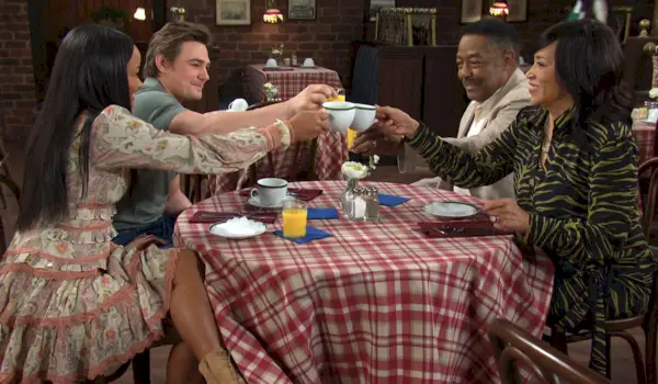 Em uma mesa do Pub, Johnny Chanel Abe e Paulina brindam com canecas de café e copos de suco de laranja