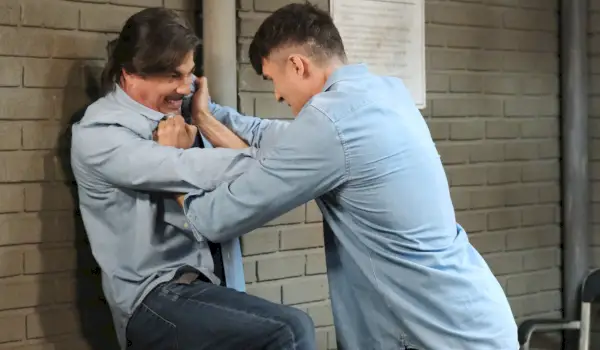Dimitri smeller Lucas mot murveggen i Pentonville. Grimaser, Lucas kjemper tilbake.