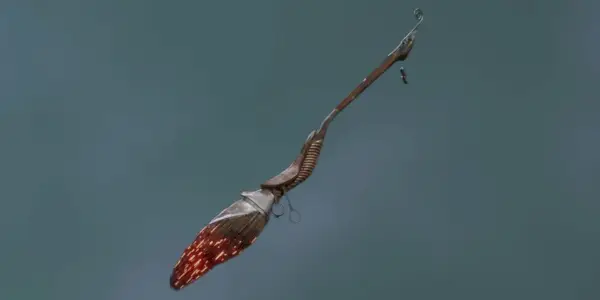 En gengivelse af Ember Dash Broom i Hogwarts Legacy mod en grå baggrund.