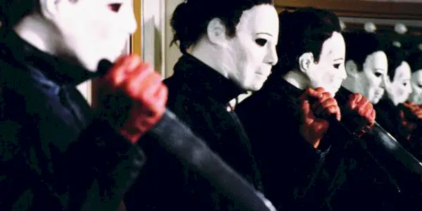 Halloween 4 Michael Myers segurando uma faca na frente de um espelho.