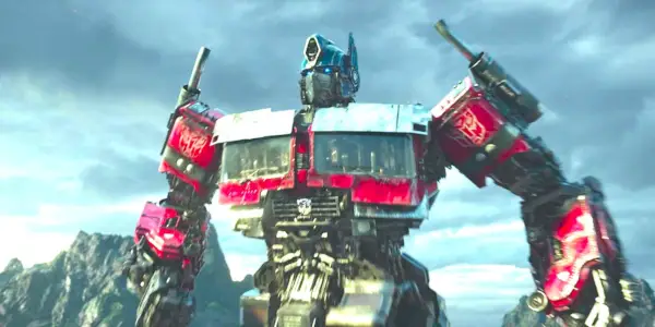 Transformers: Rise of the Beasts의 산맥 앞에서 영웅적으로 포즈를 취하는 옵티머스 프라임