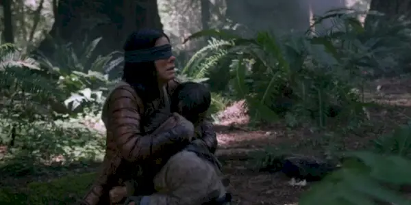 Sandra Bullock drží dieťa v lese v Bird Box