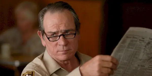 Šerif Ed Tom Bell vzhlédl od svých novin v No Country for Old Men