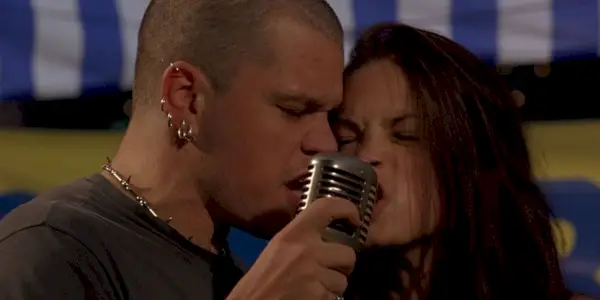 Donny (Matt Damon) et Fiona (Kristin Kreuk) se tiennent côte à côte et chantent dans un micro lors d'EuroTrip