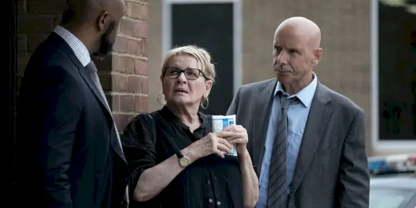 Miriam a l'air choquée alors qu'elle tient une tasse de café devant le maire de Kingstown