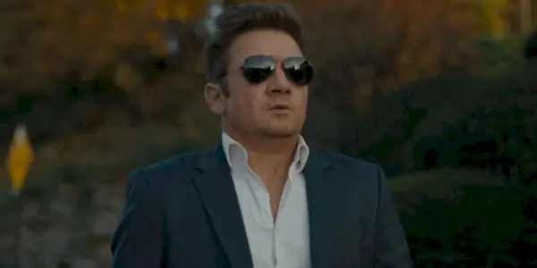 Jeremy Renner dans le rôle de Mike McLusky portant des lunettes de soleil dans l'épisode 8 de la saison 2 du maire de Kingstown.