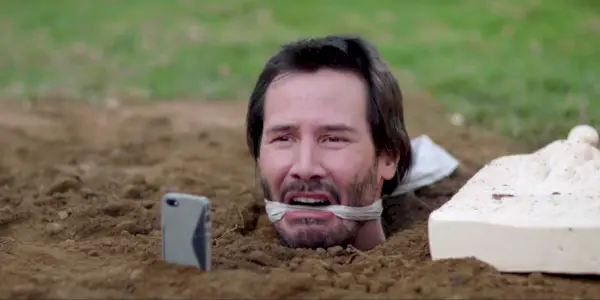 Keanu Reeves em Knock Knock enterrado até a cabeça.