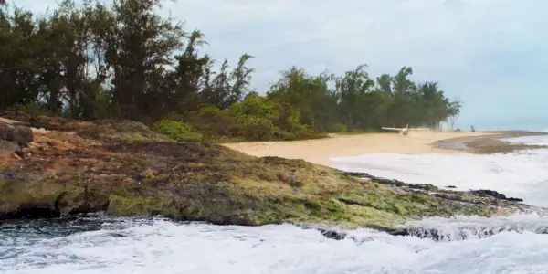 Questa immagine mostra l'acqua che si riversa sulla spiaggia