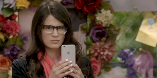 Piper usa il suo telefono per registrare una veglia in Scream The TV Series.
