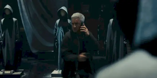 Dermot Mulroney circondato dai mantelli di Ghostface in Scream 6