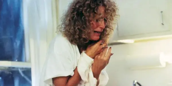 Glenn Close nei panni di Alex che piange e tiene le mani alzate in Attrazione fatale