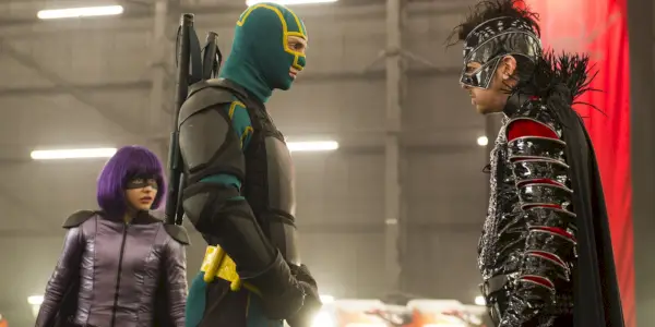 Kick-Ass 2에서 노란색과 녹색 양복을 입은 Kick-Ass와 보라색 양복을 입은 Hit-Girl이 Chris와 대결합니다.