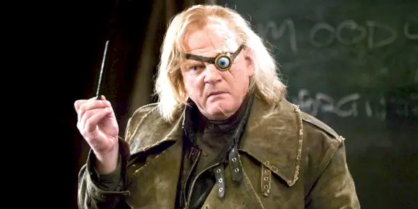 Mad Eye Moody Crouch Jr. sotto la pozione PolyJuice mentre tiene la bacchetta