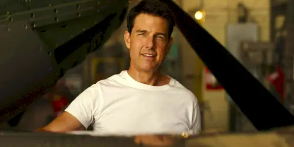 Tom Cruise som Maverick iført hvid skjorte og står ved flyet i Top Gun: Maverick