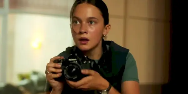 Cailee Spaeny como Jessie en Civil War. Ella sostiene una cámara, a punto de tomar una foto.