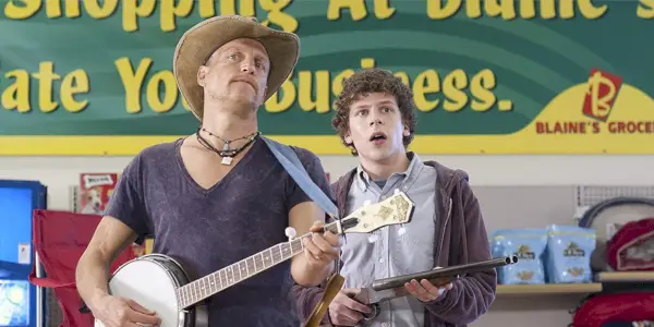 Tallahassee tocando un banjo y Colón sosteniendo un arma en Zombieland.