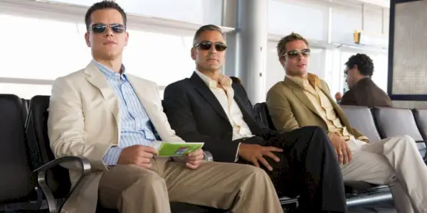 Matt Damon, George Clooney y Brad Pitt sentados en un aeropuerto de Ocean