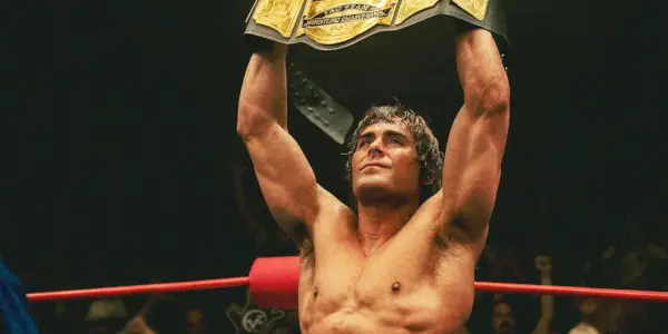 Zac Efron jako Kevin Von Erich drží pás šampiona ve wrestlingu ve filmu Železný dráp.