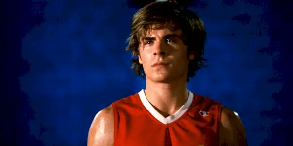 Troy Bolton (Zac Efron) mžoural, zatímco měl na sobě basketbalový dres na pódiu ve High School Musical 3.