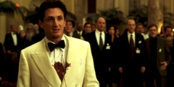 Sean Penn stojí s krvavou hruďou v bielom smokingu v hre The Game