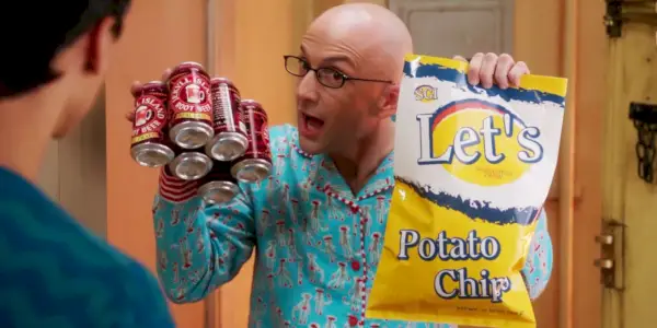 Dean Pelton (Jim Rash) usa pijama e segura root beer e batatas fritas na Comunidade.