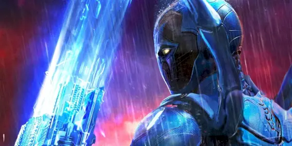 Aufnahme von Blue Beetle von hinten, mit gezücktem Energieschwert und fallendem Regen.