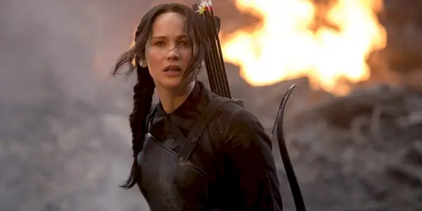 Katniss stoi na ulicy przed ogniem w Igrzyskach Śmierci Kosogłos, część 1.