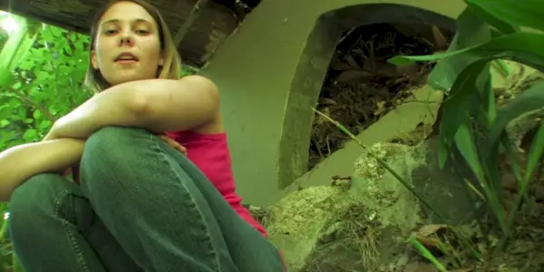 Amy (Amber Perkins) accroupie sous un pont dans Megan a disparu.