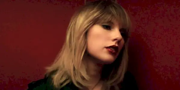 Taylor Swift mot rød bakgrunn i musikkvideoen I Don