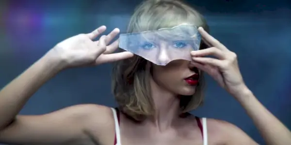 Taylor Swift holder opp glasset i musikkvideoen sin for Style