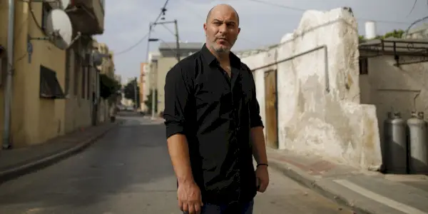 Doron (Lior Raz) in piedi al centro di una strada a Fauda.