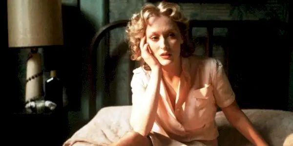Sophie (Meryl Streep) assise sur un lit, la tête posée sur sa main dans Sophie