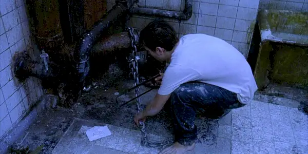 Adam píli reťaz v Saw