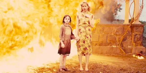 Michelle Williams tiene per mano una ragazzina mentre è circondata dal fuoco a Shutter Island