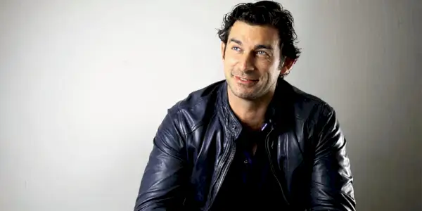 Christian Solimeno sourit sur fond blanc