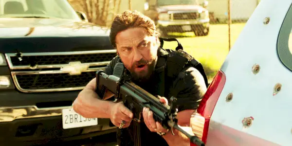 Gerard Butler dans le rôle de Big Nick avec une arme à feu dans Den of Thieves
