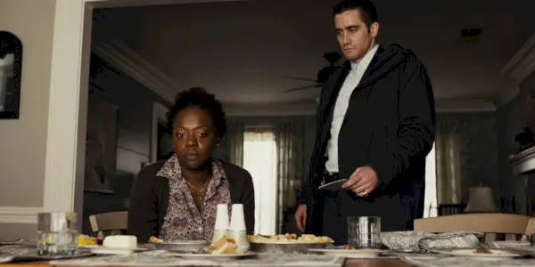 Prisoners의 테이블에서 Viola David 옆에 서 있는 Jake Gyllenhaal