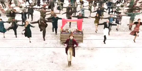 Timothee Chalamet a Wonka Ensemble hrajú vonku s hudobným číslom