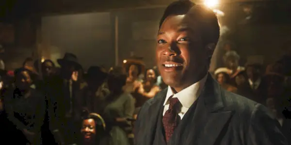 Corey Hawkins als Harpo steht vor einer Menschenmenge und lächelt in „The Color Purple“.