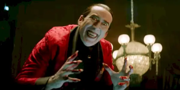 Nicolas Cage sorrindo assustadoramente como Drácula em Renfield.