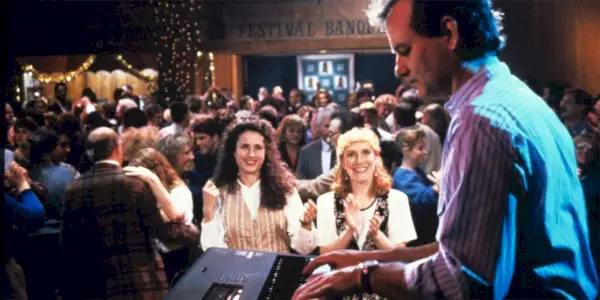 Phil (Bill Murray) joue du piano sur scène pendant que Rita (Andie MacDowell) regarde la foule dans Groundhog Day.