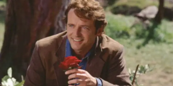 Gary Hallet smiler og holder en rose i praktisk magi