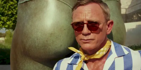 Benoit Blanc (Daniel Craig) se tient à côté d'une sculpture dans Glass Onion