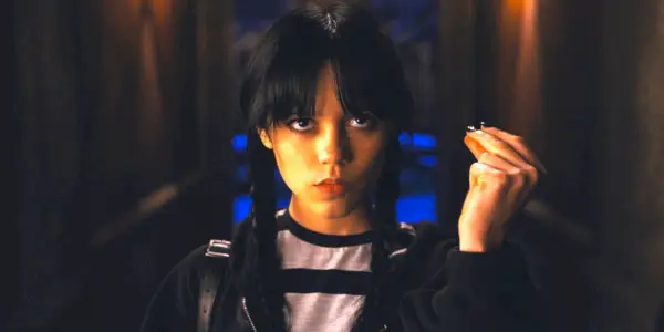 Onsdag (Jenna Ortega) kigger opad og knipser med fingrene i Netflix