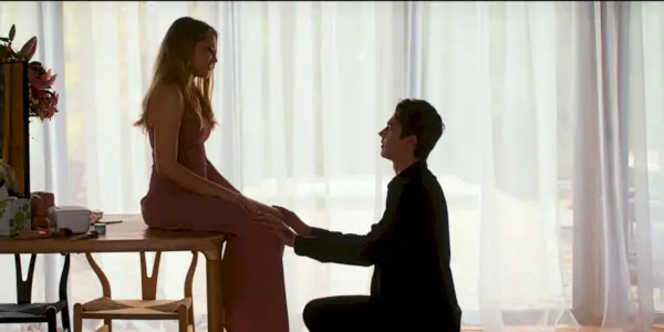 Tessa sedí na stole, zatiaľ čo Hardin si kľakne, aby požiadal o ruku v After Everything.