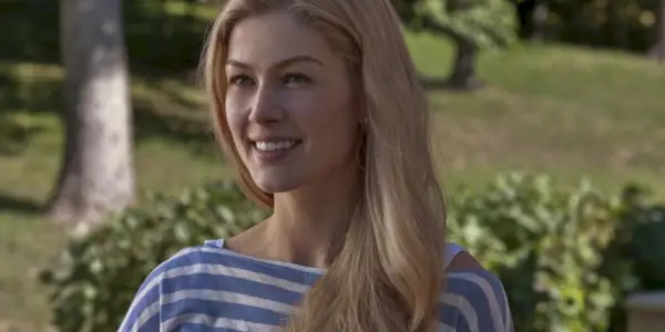 איימי (רוזמונד פייק) עומדת בחוץ ומחייכת ב-Gone Girl