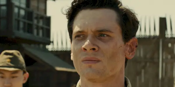 Louie Zamperini en prisonnier dans Unbroken.