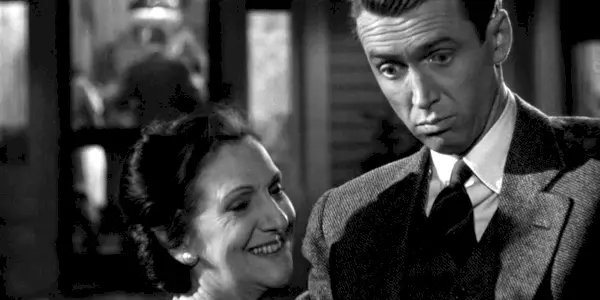 Beulah Bondi als Mrs. Bailey lächelt und James Stewart als George Bailey sieht darin überrascht aus